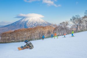 People skiing on the snow slope and Mt.Yotei as a background in Niseko Ski area, Hokkaido
