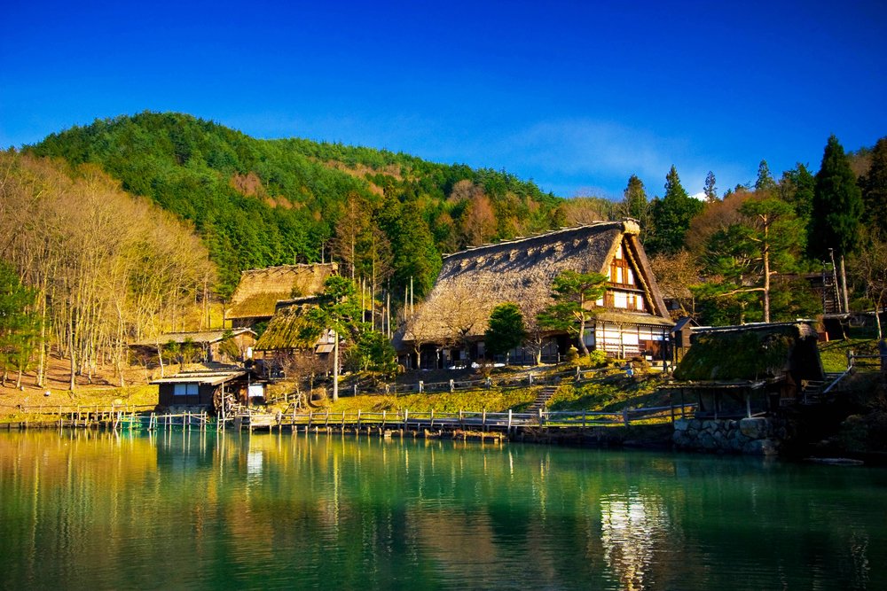 Hida Folk Village (Hida No Sato) with blue sky in spring season, Takayama, Japan. An open air museum with over 30 traditional houses from the Hida region, including Gassho-Zukuri style farmhouses
