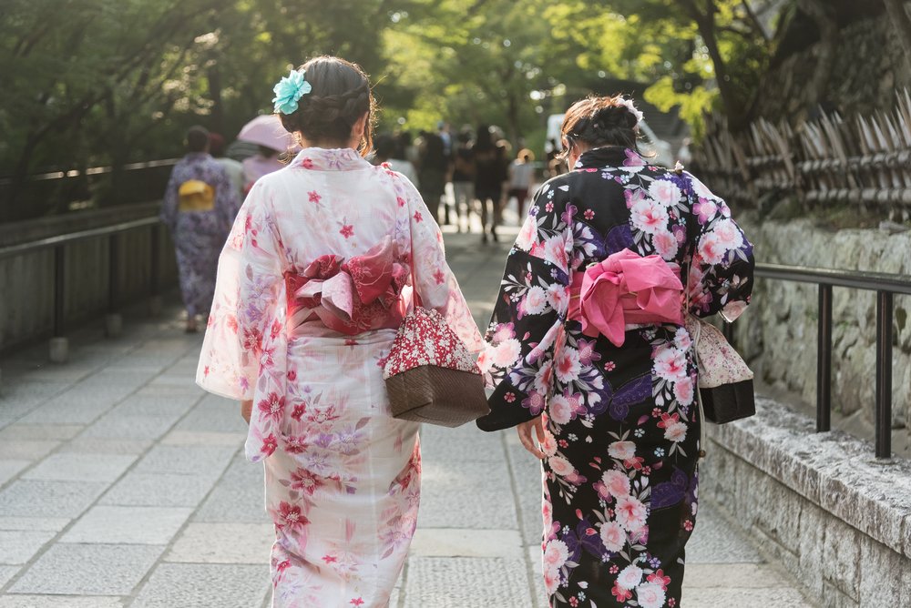 Two Japanese Women Wearing Kinomo Costume walking on the Cobble Stone Walkway in the Temple in Kyoto