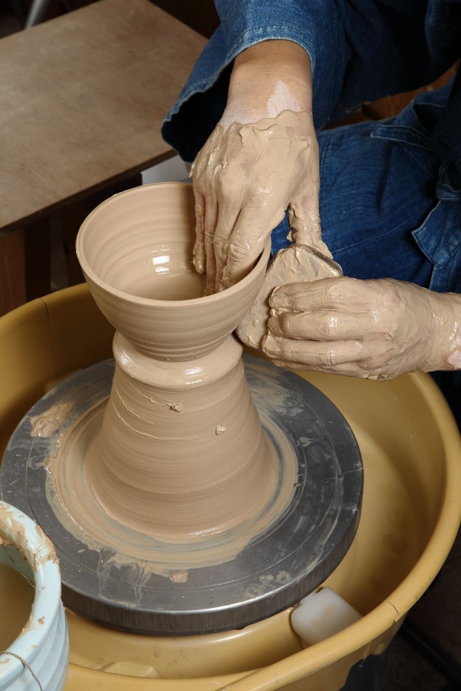 apanese pottery master:Taking shape:Japanese pottery master in his studio. A creation starting to take shape
