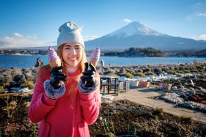 beautiful smile asian girl holding blueberry soft serve ice cream cone with mount fuji